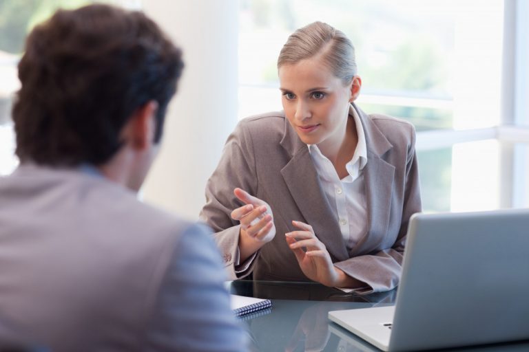 A woman seriously discussing with a man in her office