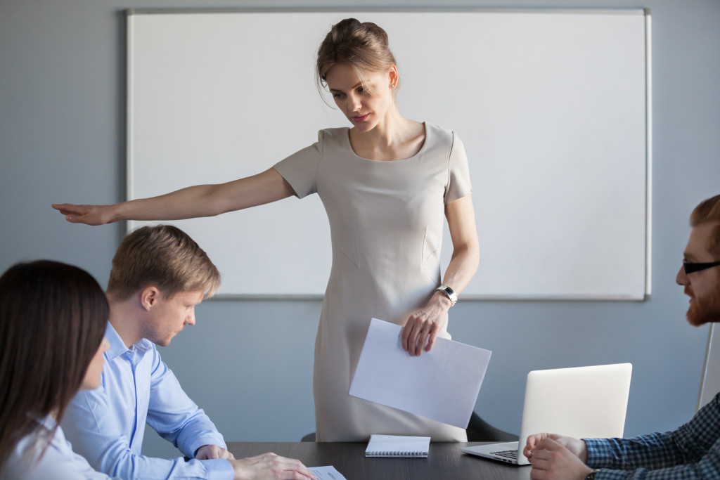 female boss seriously asks male employee to leave the meeting implying he's fired
