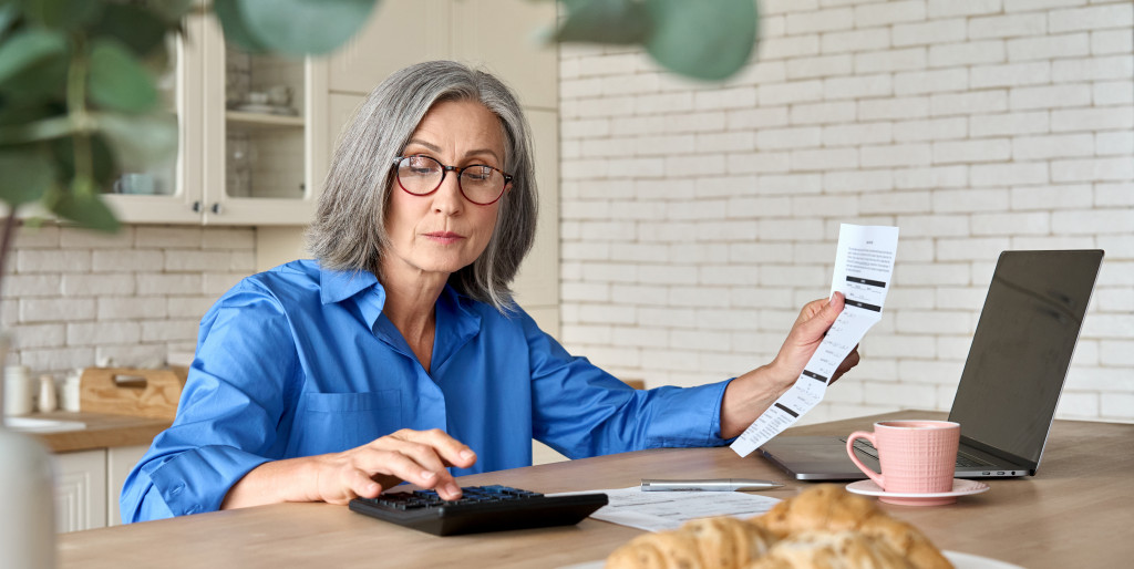 Serious middle aged woman at table working on bank payments